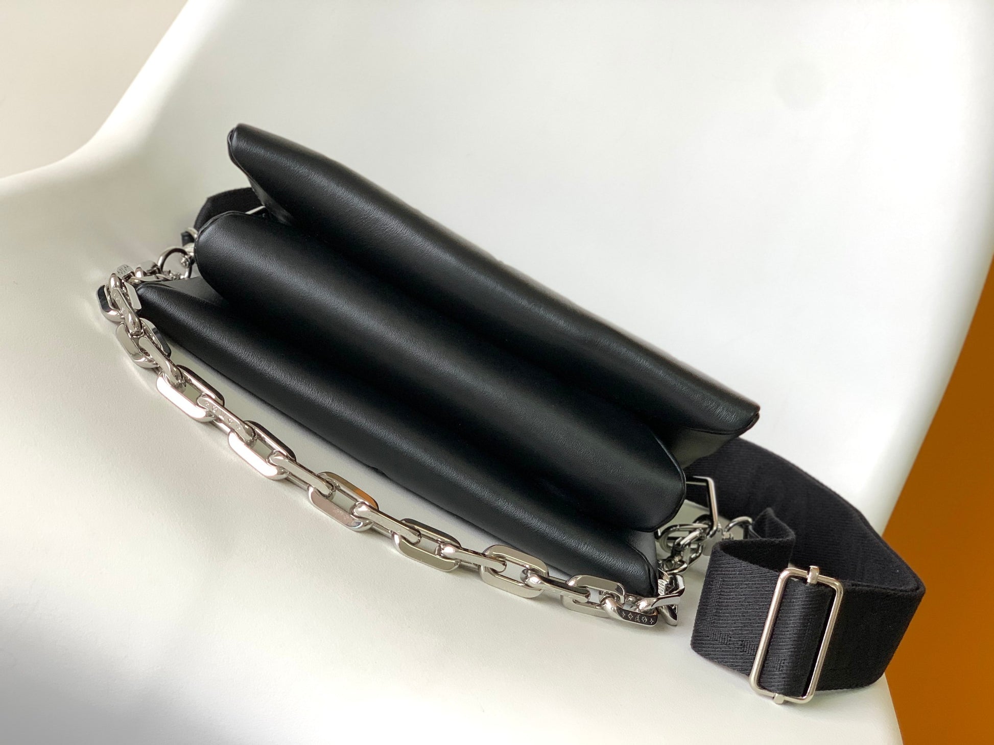 Black Embossed Monogram Crossbody Bag with Chain Detail and Wide Adjustable Strap