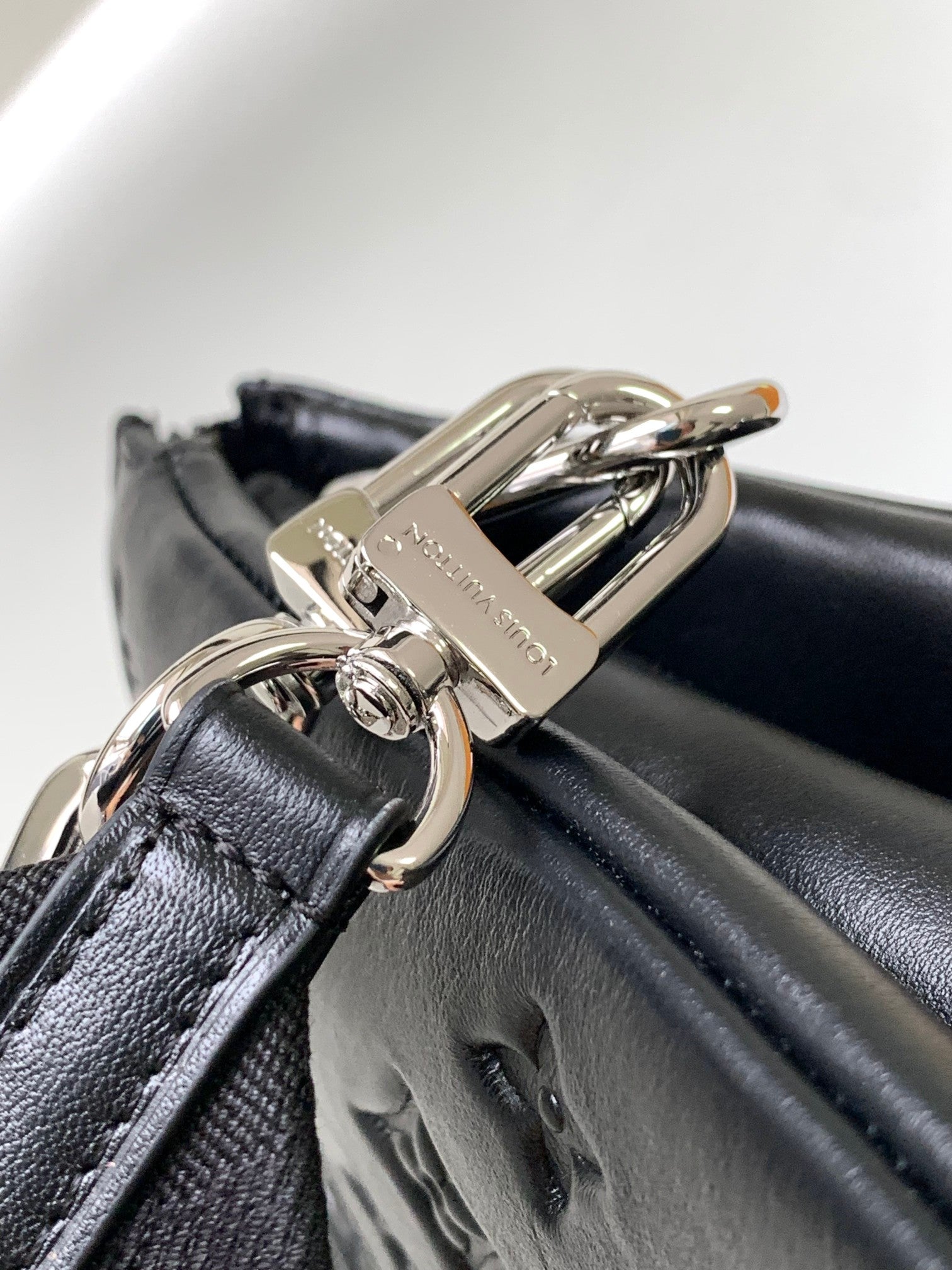 Black Embossed Monogram Crossbody Bag with Chain Detail and Wide Adjustable Strap