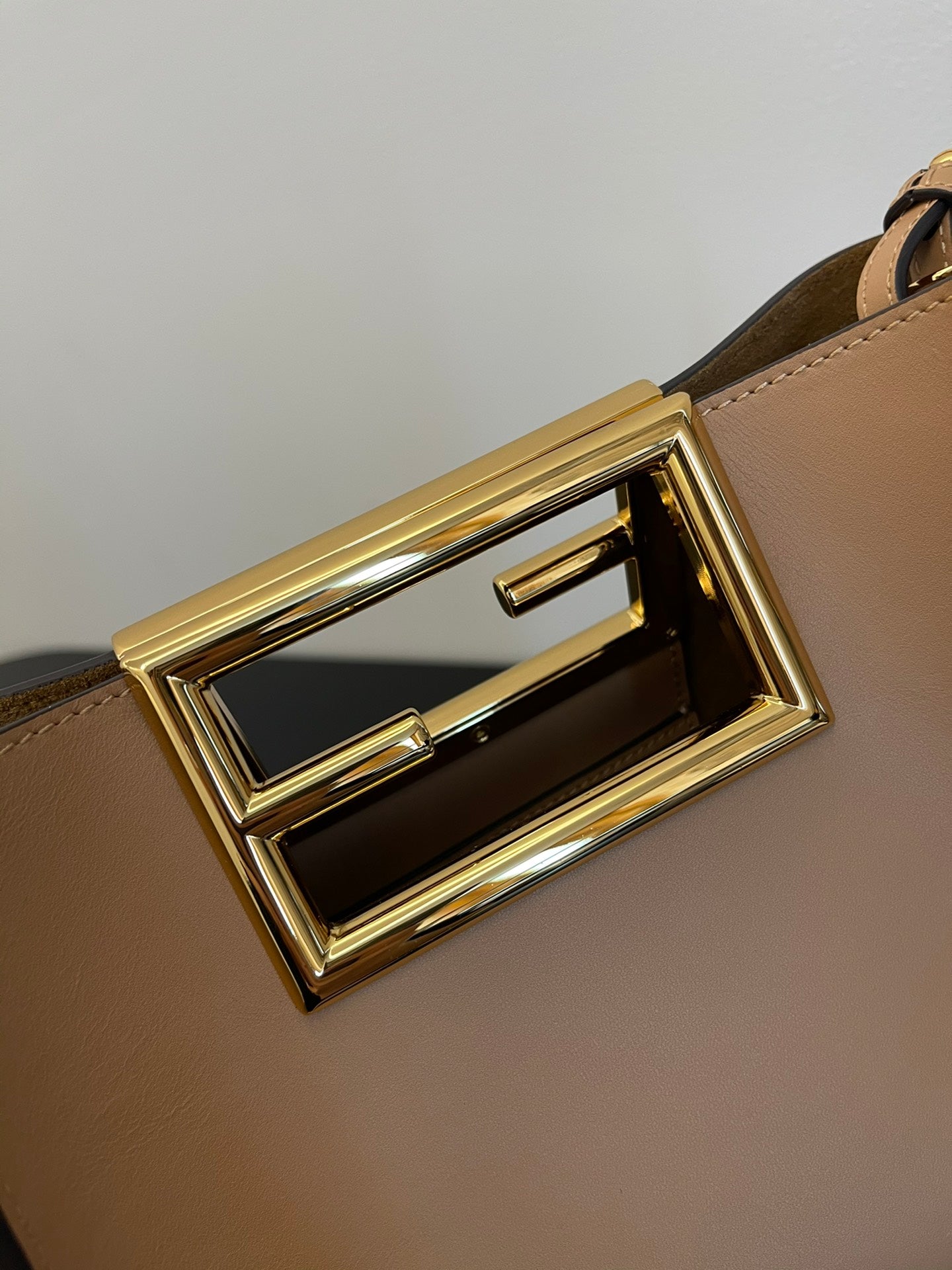 Tan Leather Bucket Bag with Gold Geometric Clasp and Shoulder Strap
