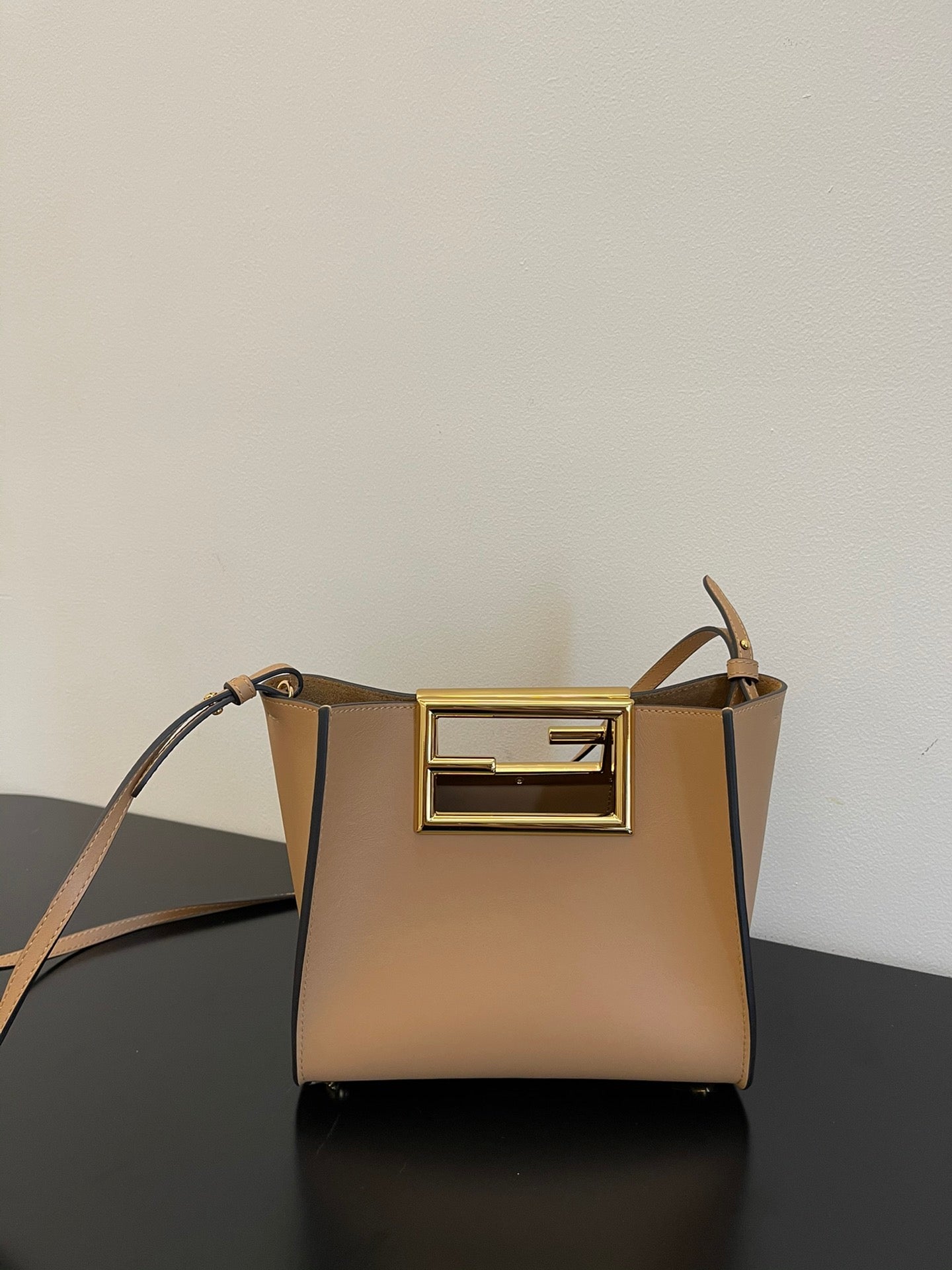 Tan Leather Bucket Bag with Gold Geometric Clasp and Shoulder Strap
