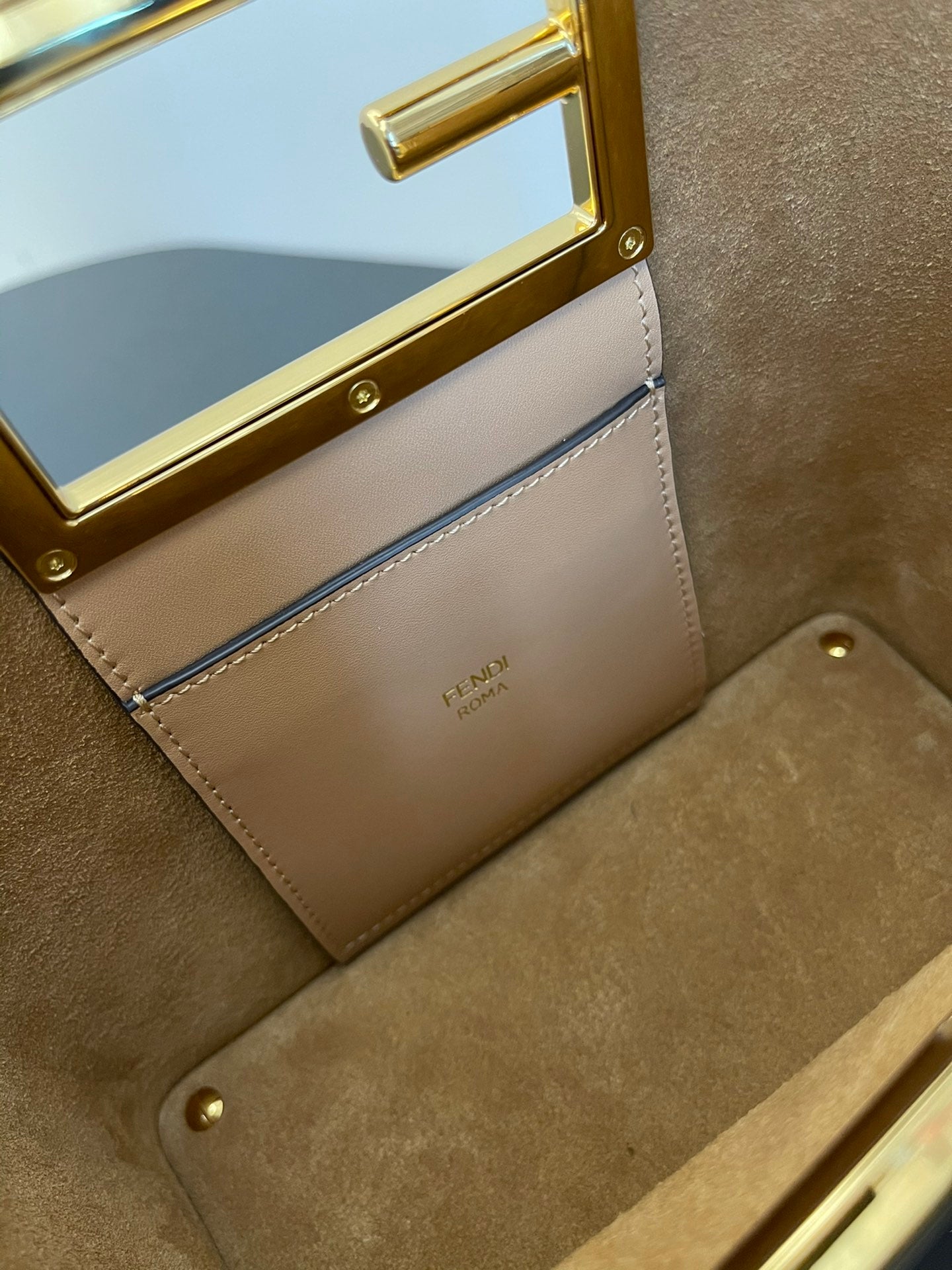 Tan Leather Bucket Bag with Gold Geometric Clasp and Shoulder Strap