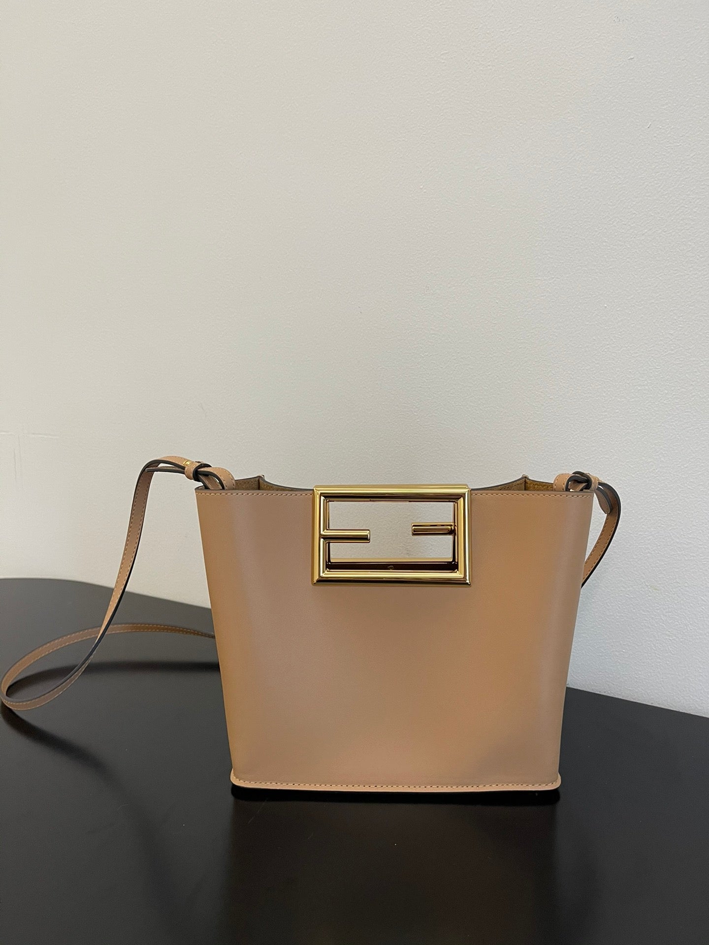 Tan Leather Bucket Bag with Gold Geometric Clasp and Shoulder Strap