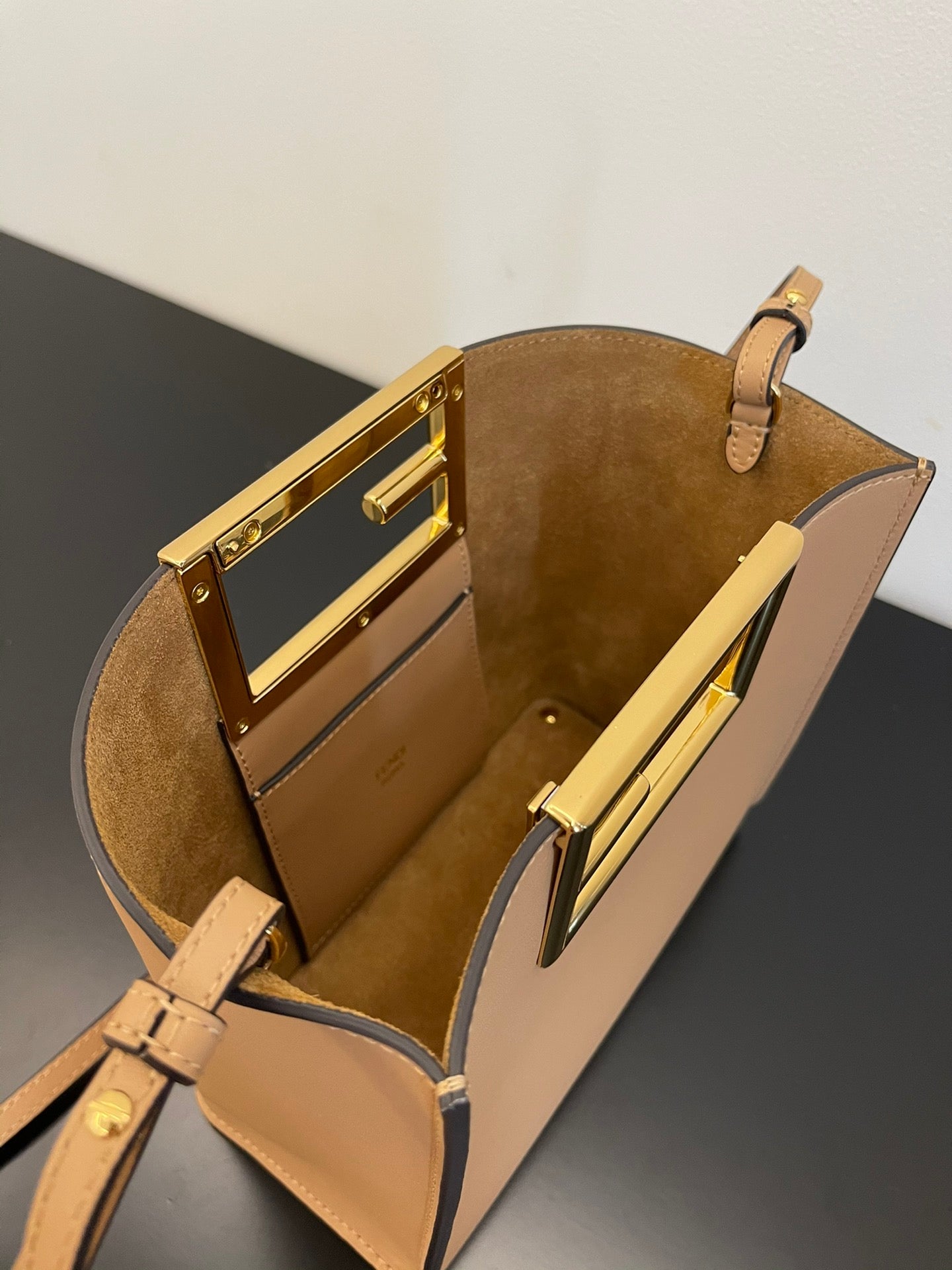 Tan Leather Bucket Bag with Gold Geometric Clasp and Shoulder Strap