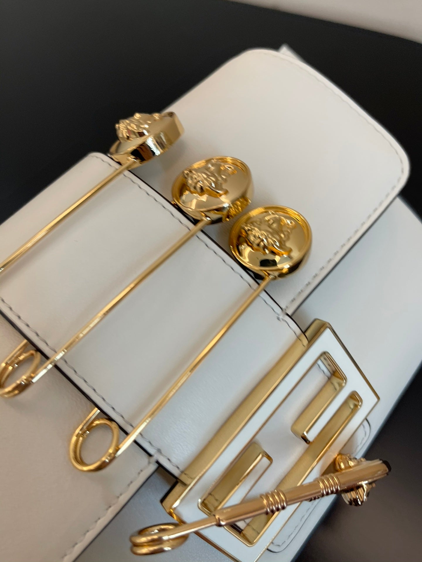 Elegant White Leather Mini Bag with Gold Flower Safety Pin Details