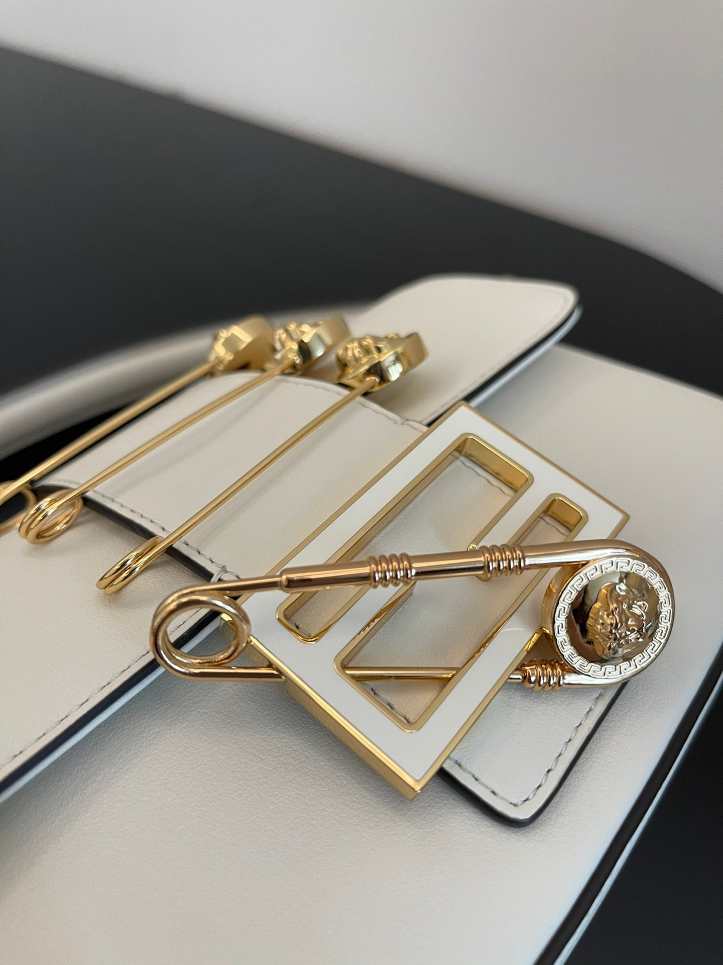 Elegant White Leather Mini Bag with Gold Flower Safety Pin Details