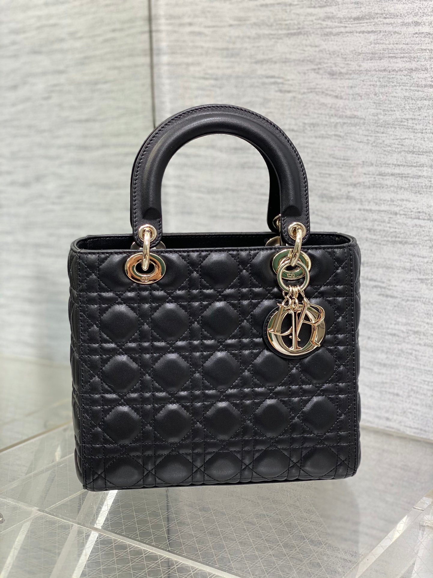 Dior Elegant Black Quilted Leather Handbag with Top Handle and Gold Charms