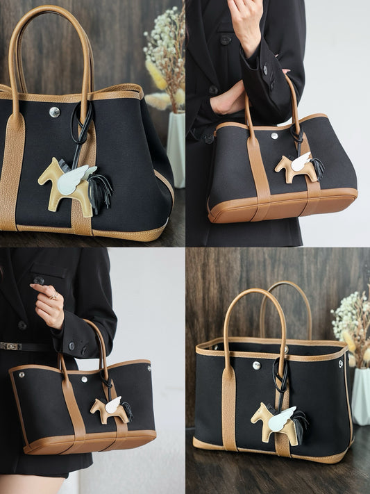 Elegant Black Canvas Tote Bag with Tan Leather Trim and Pegasus Charm