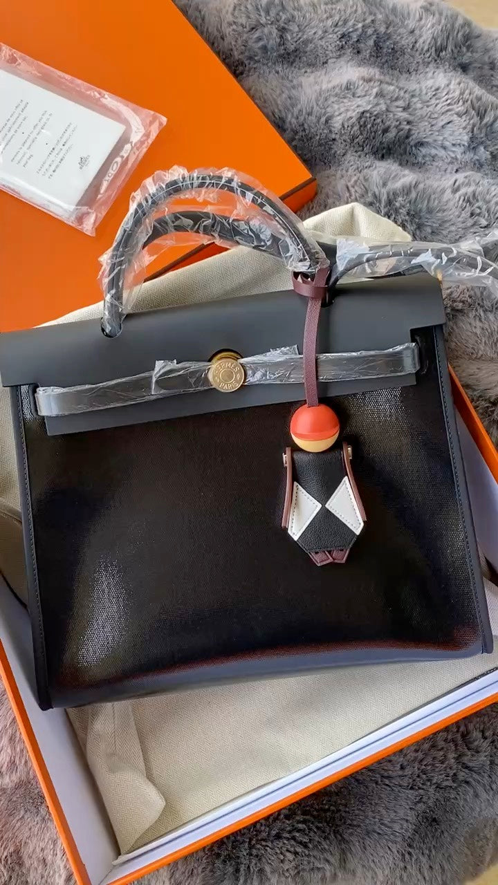 Luxury Black Leather Top Handle Handbag with Gold-Tone Hardware and Bag Charm