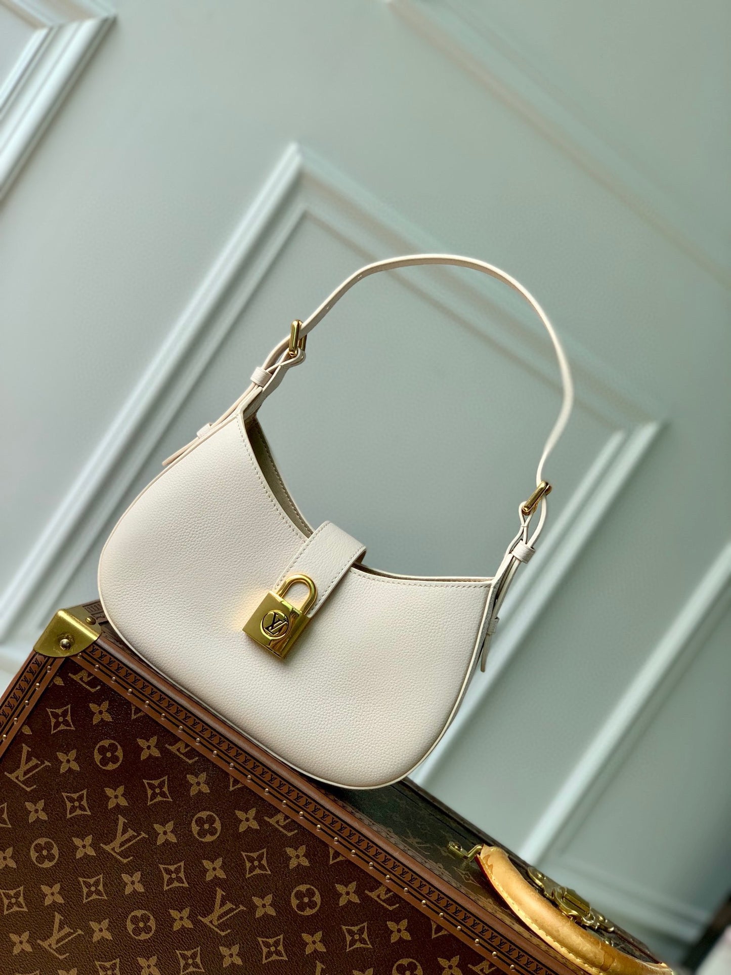 Elegant Cream Leather Crescent Shoulder Bag with Gold Padlock Detail