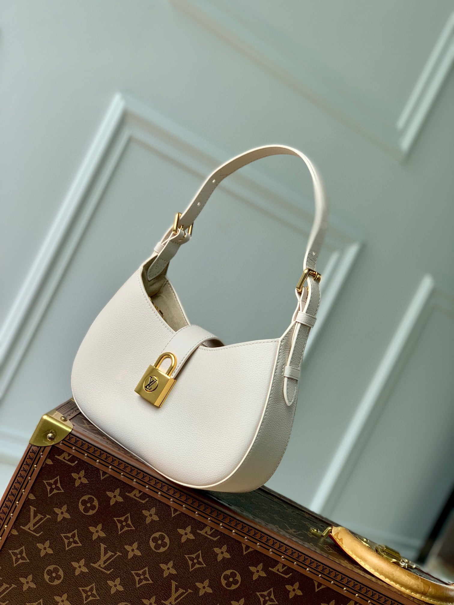 Elegant Cream Leather Crescent Shoulder Bag with Gold Padlock Detail