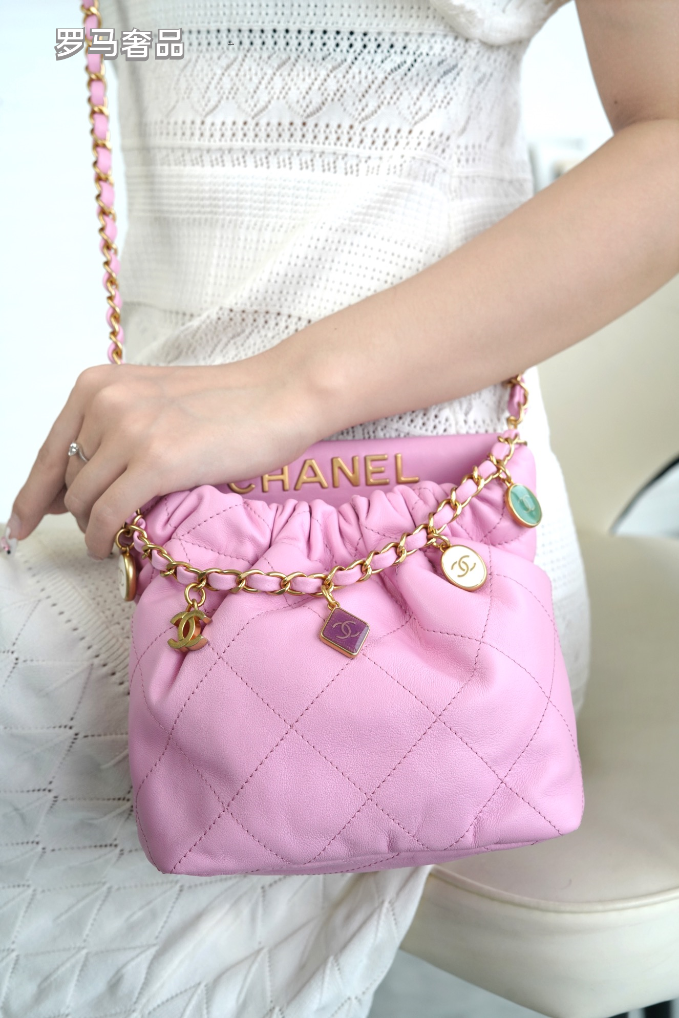 Pink Quilted Leather Bucket Bag with Gold-Tone Chain and Decorative Charms